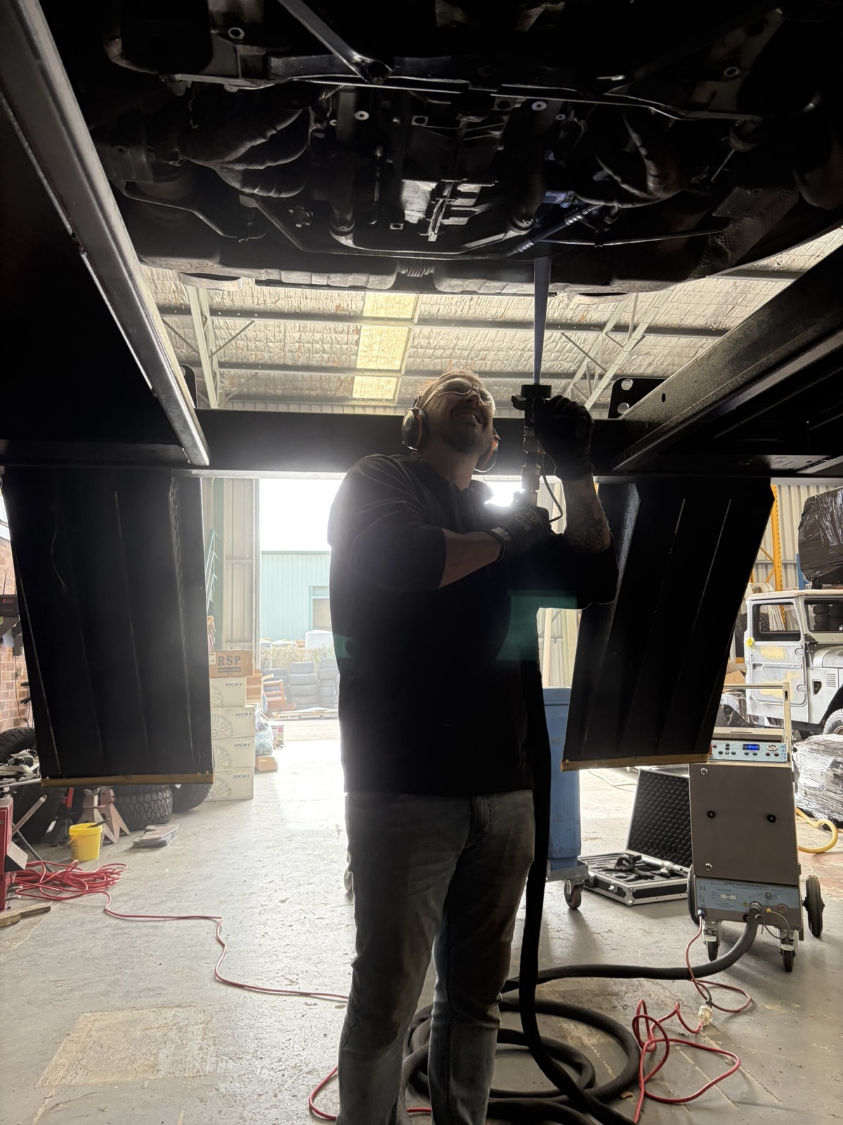 Operator blasting the rear underbody with the Cryonomic unit behind